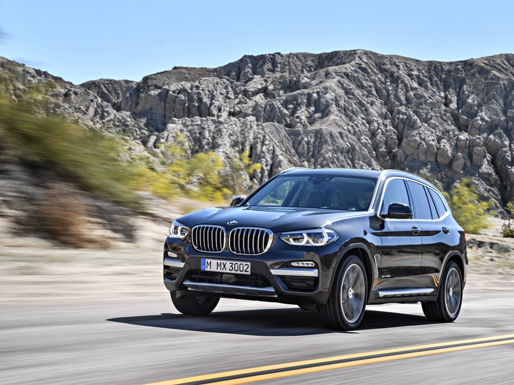 Черный красивый автомобиль BMW X3, 2018 на фоне гор