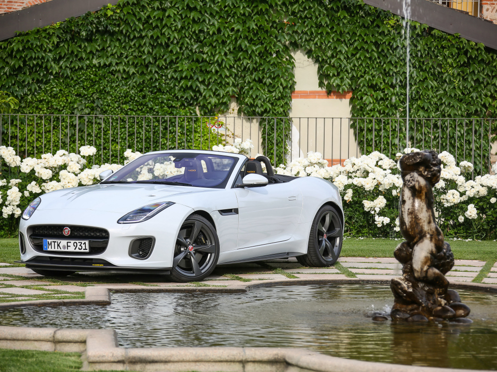 Белый автомобиль кабриолет Jaguar F-Type у фонтана