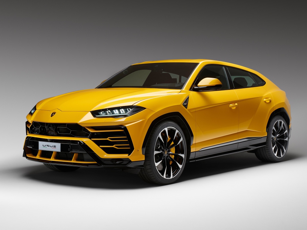 Желтый спортивный автомобиль Lamborghini Urus, 2018 на сером фоне