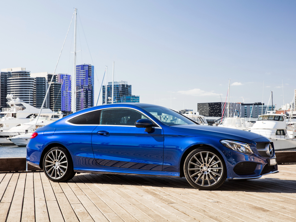 Синий автомобиль Mercedes-Benz C205 на фоне города