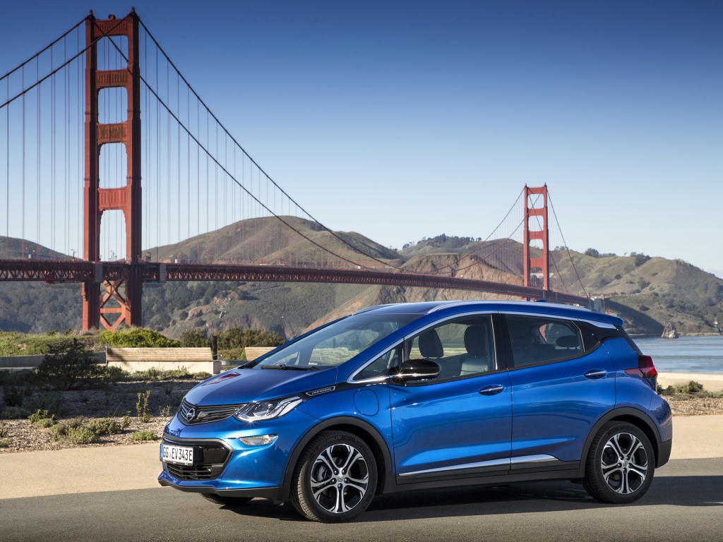 Синий автомобиль Opel Ampera-e, 2017  года на фоне моста 