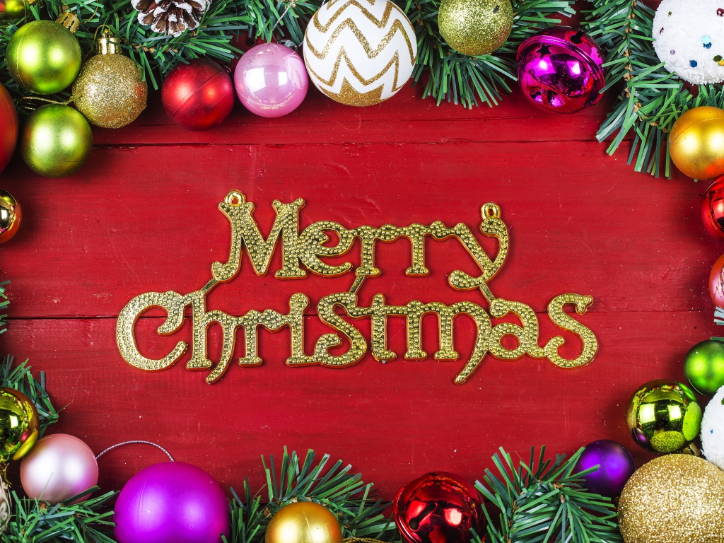 Надпись Merry Christmas на красном фоне с елочными игрушками на Рождество