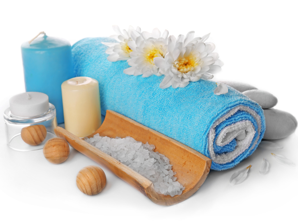 Полотенце, свечи, соль и цветы хризантемы на белом фоне