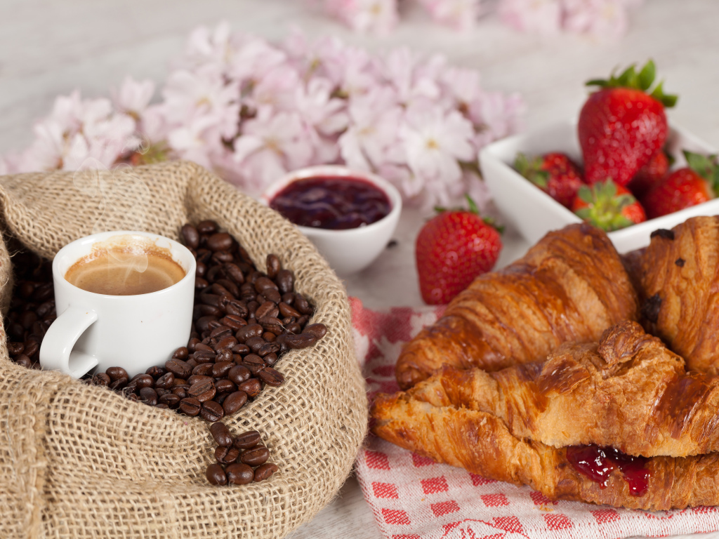 Чашка кофе в мешке с кофейными зернами и свежими круассанами