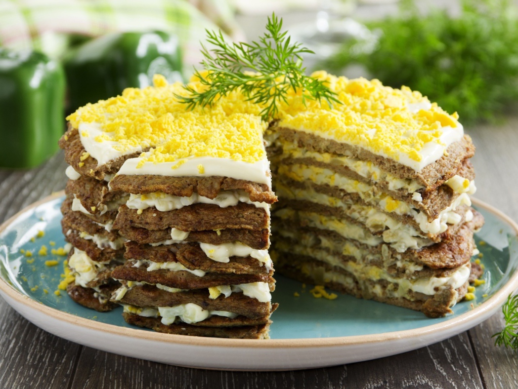 Аппетитный печеночный торт на блюде 