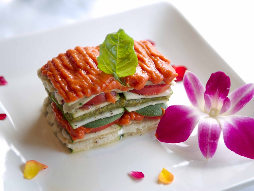 Аппетитный овощной бутерброд на белой тарелке с цветком