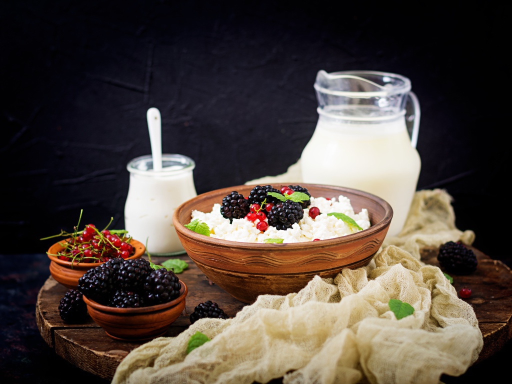 Творог с ягодами и свежим молоком на столе на завтрак