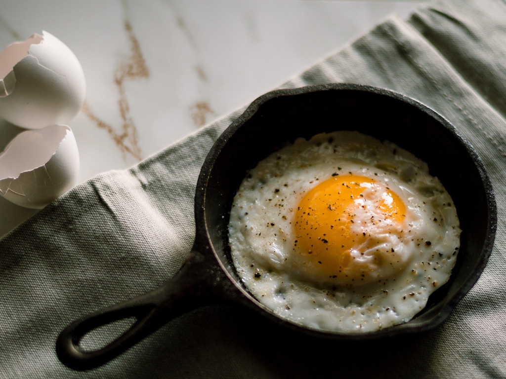 Яичница глазунья на столе в маленькой сковороде