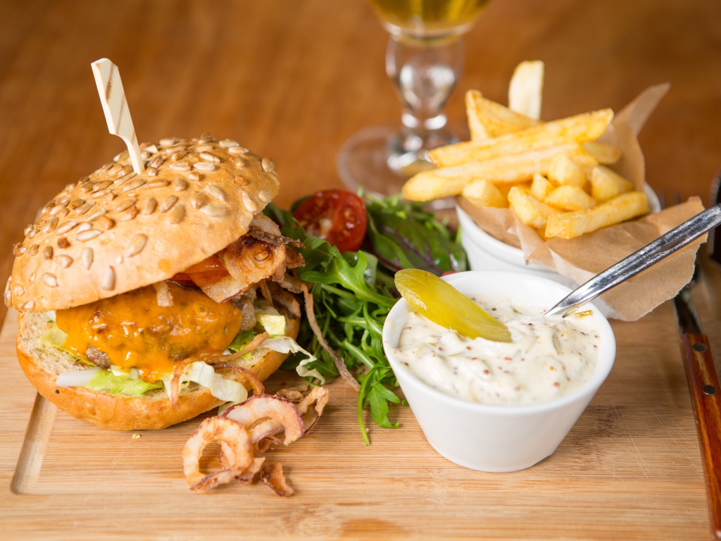 Гамбургер и картошка фри на столе с соусом