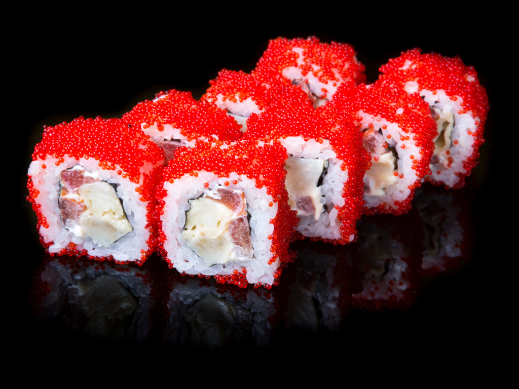 Японские роллы с красной икрой на черном фоне 