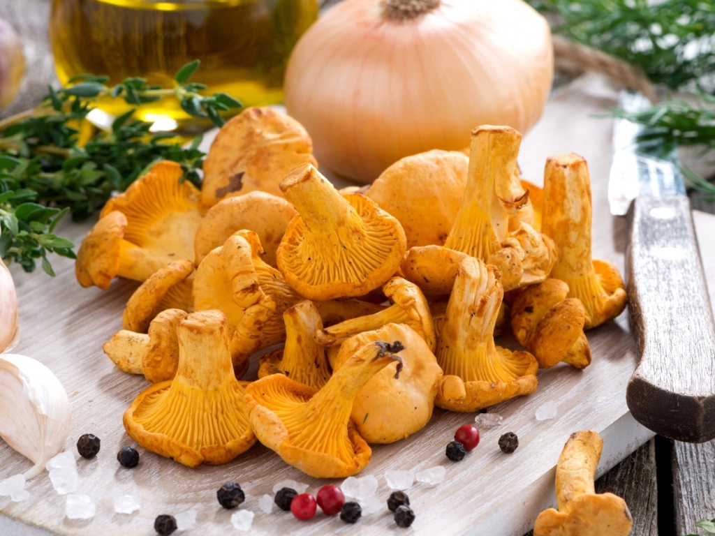 Грибы лисички и овощи на деревянной доске 