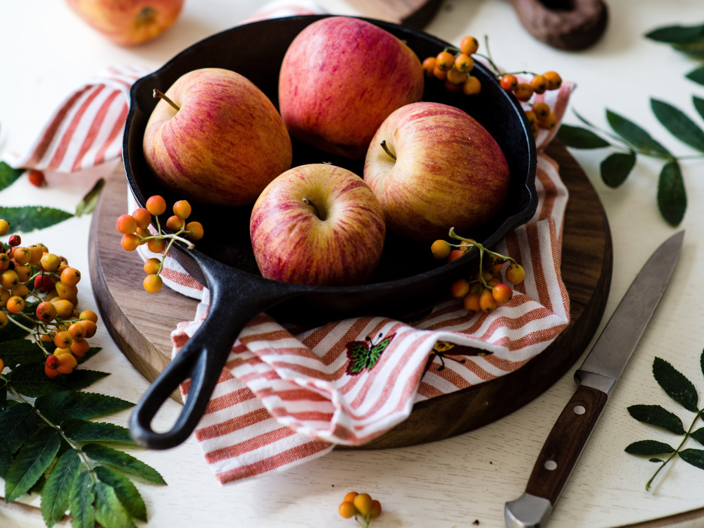 Красивые красные яблоки на сковороде с ягодами рябины