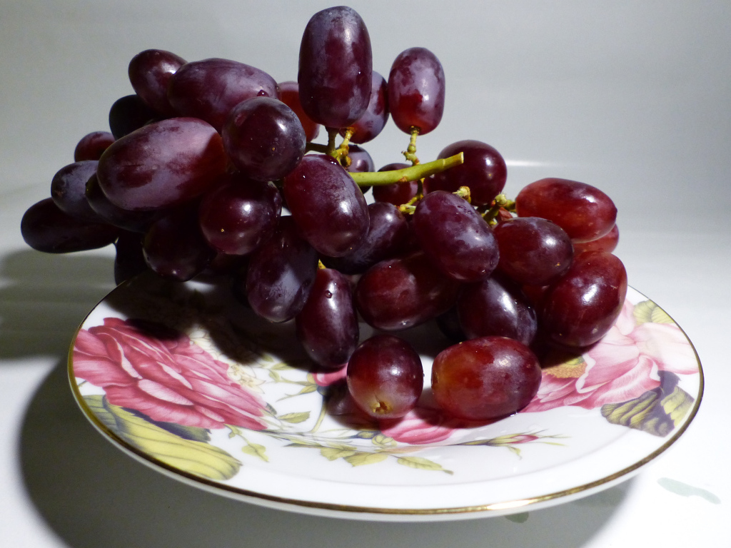Розовый виноград на тарелке крупным планом