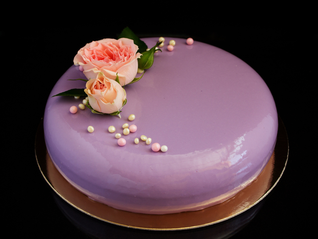 Глянцевый круглый фиолетовый торт с цветами розы на черном фоне