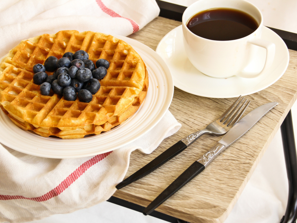 Сладкие вафли с черникой и чашкой кофе на завтрак