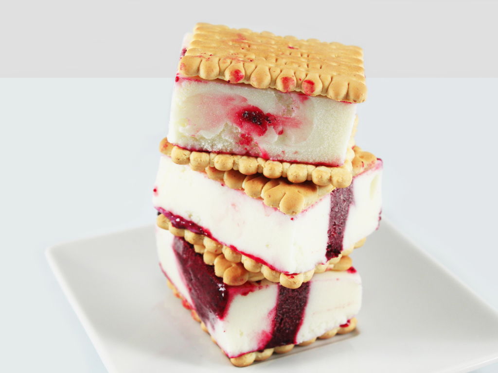 Три кусочка мороженого с печеньем на сером фоне