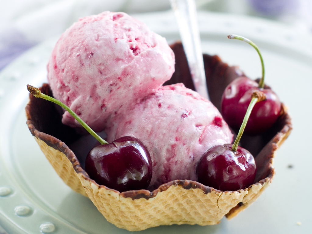 Два шарика вишневого мороженого в вафельной корзинке