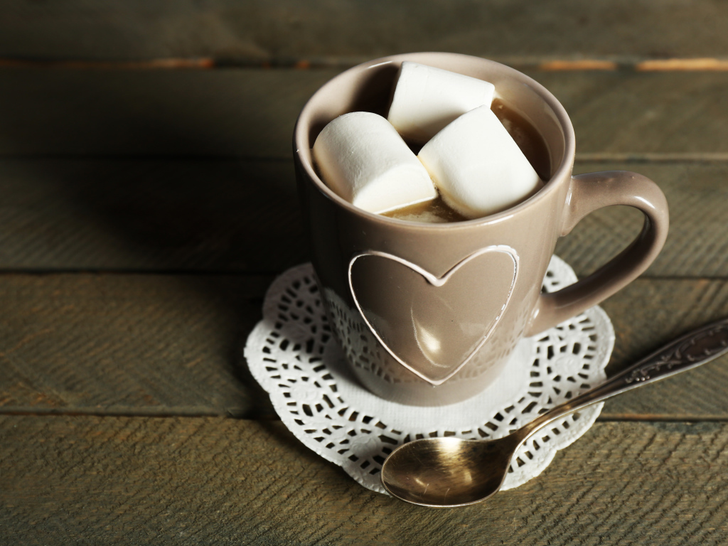 Чашка какао с кусочками маршмеллоу на кружевной салфетке