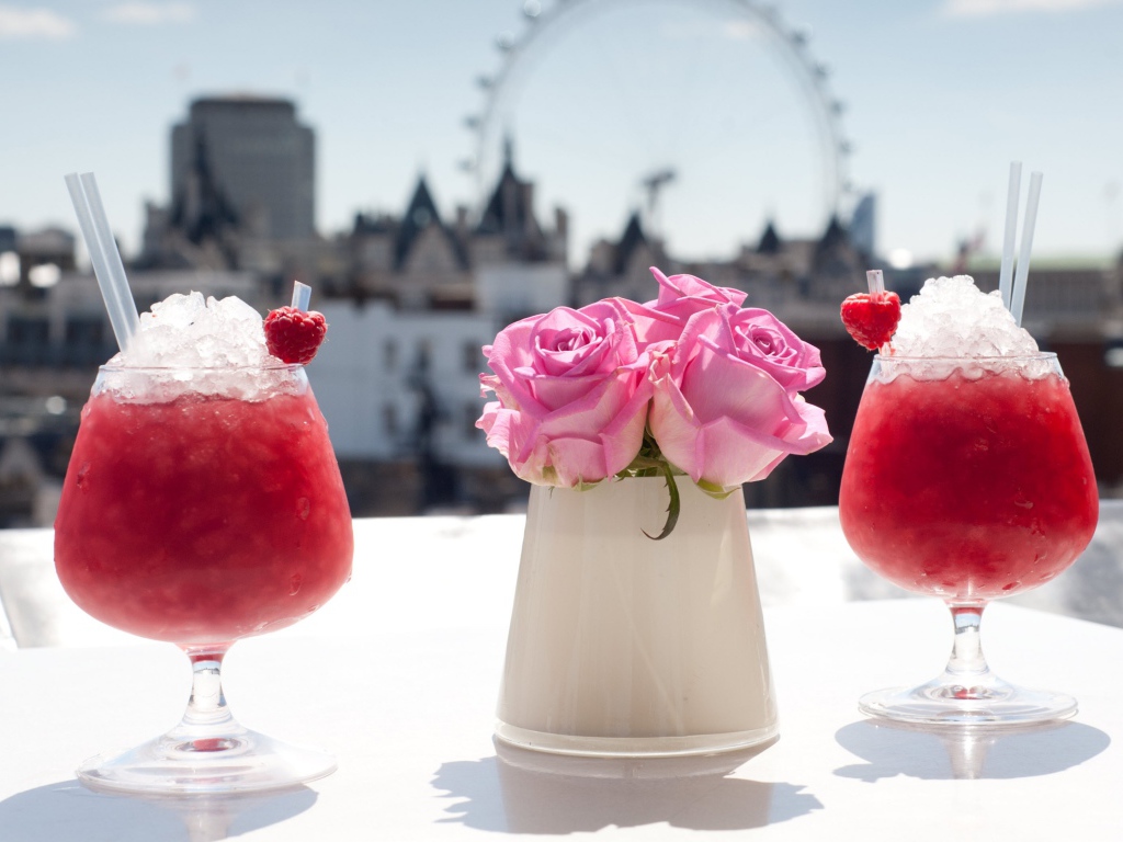 Два коктейля со льдом на столе с цветами