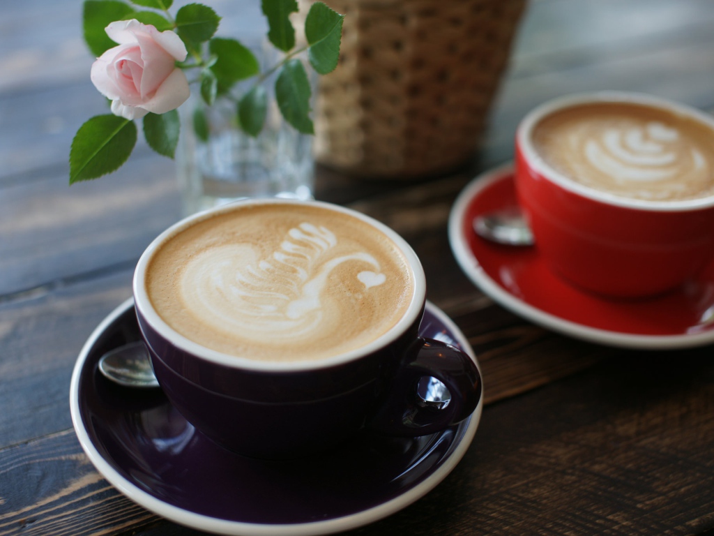 Две чашки кофе на столе с розовой розой