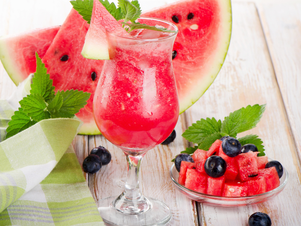 Арбузный сок со льдом в бокале со свежим арбузом и ягодами черники