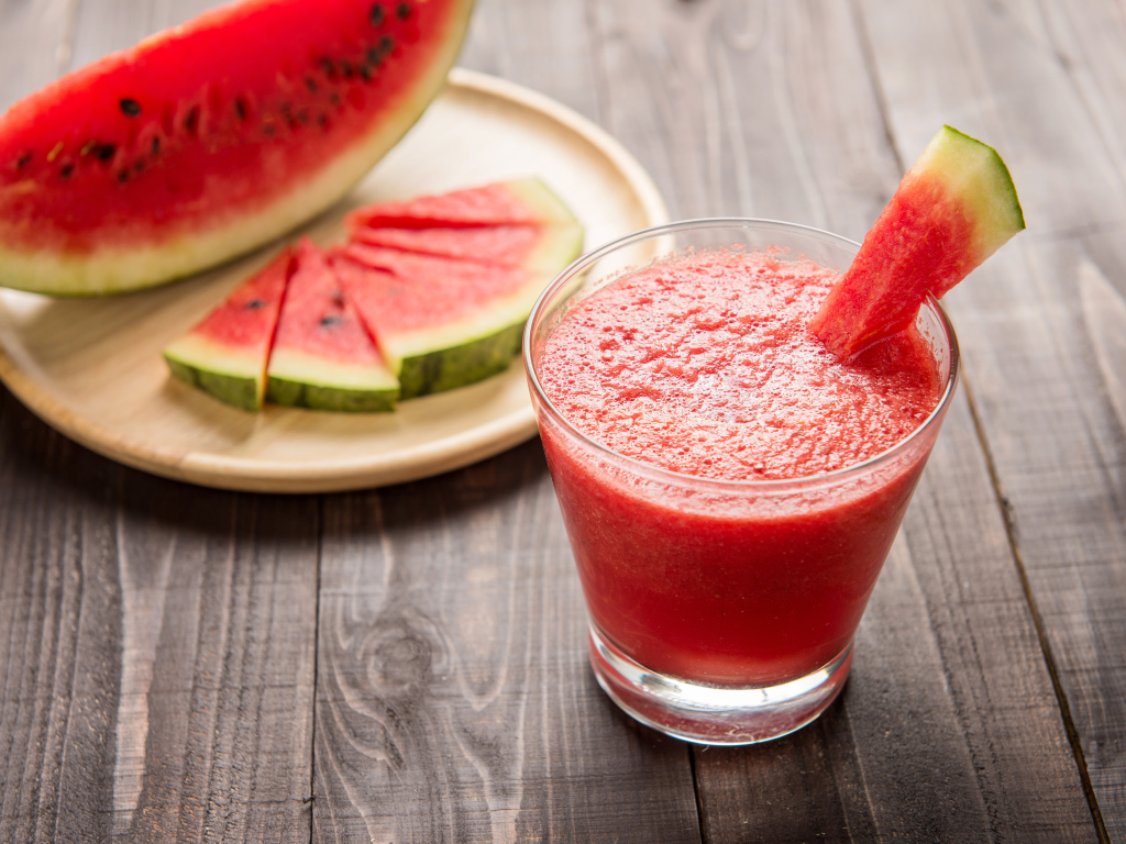 Арбузный смузи в стеклянном стакане с кусочками арбуза