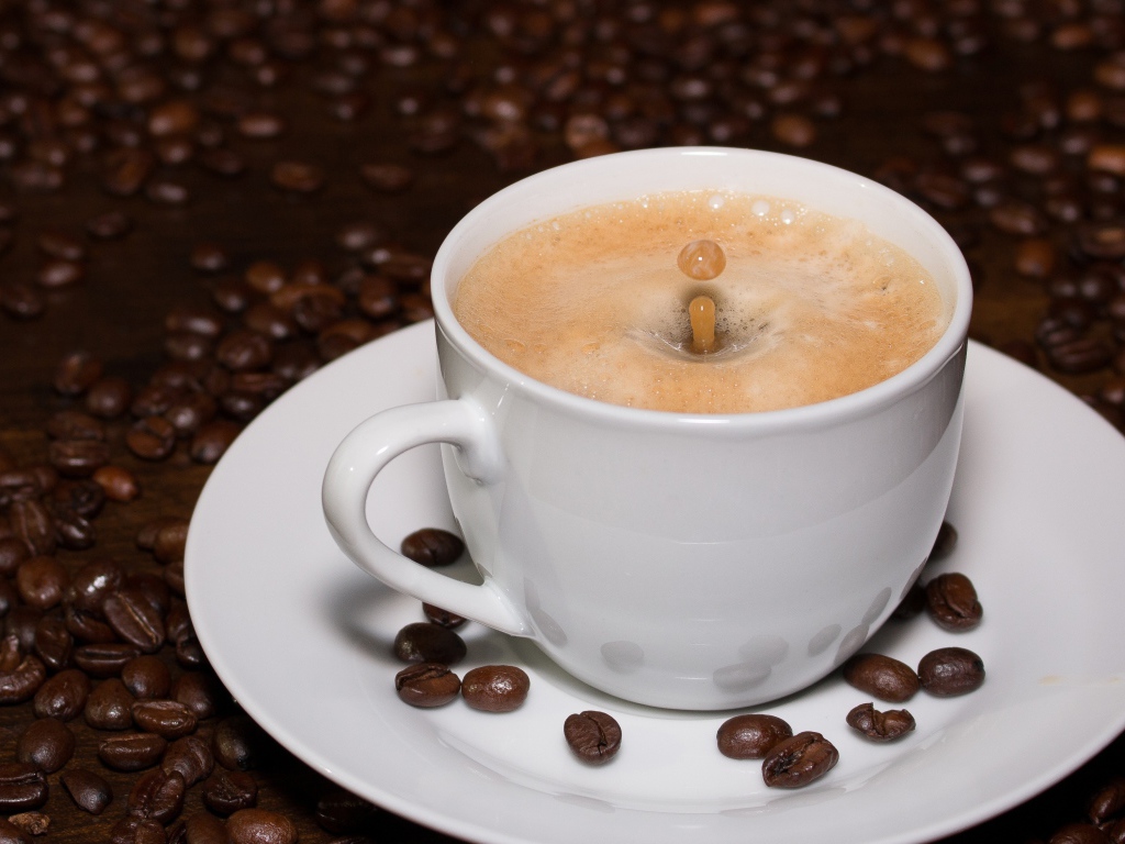 Белая большая чашка кофе с зернами на столе