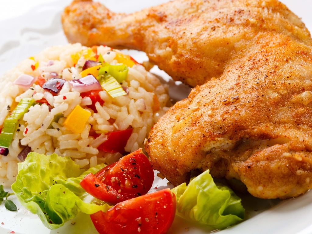 Аппетитный жареный куриный окорочок с рисом и овощами