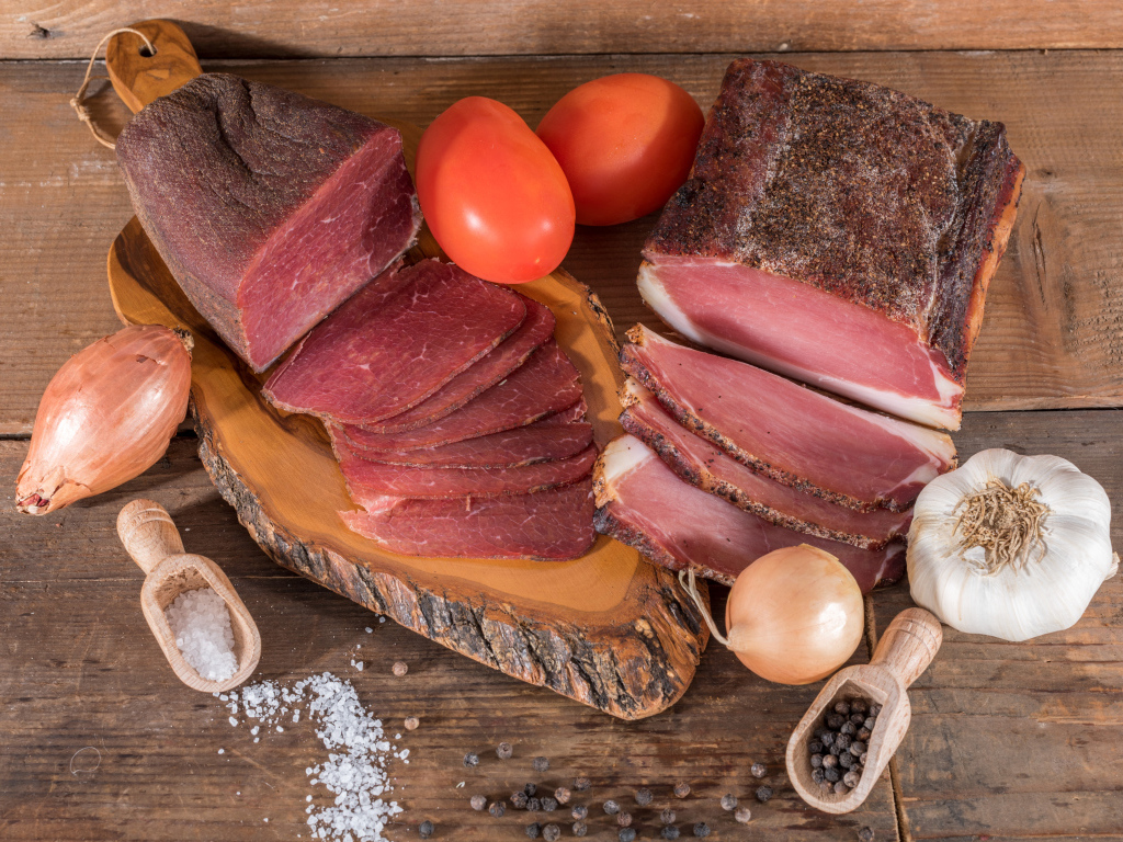 Вкусное вяленое мясо со специями на разделочной доске