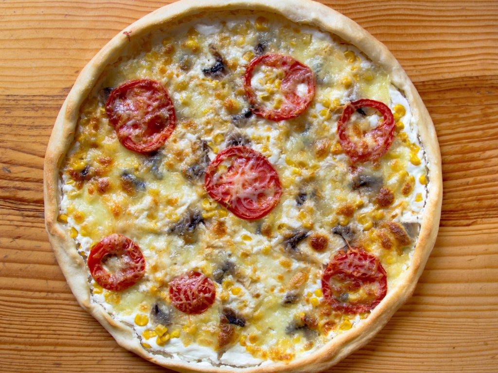 Итальянская пицца с помидорами и сыром на столе