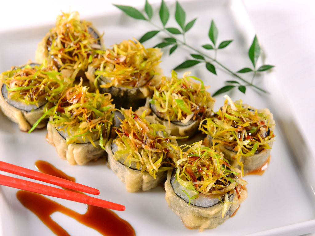 Горячие суши с овощами на белой тарелке 