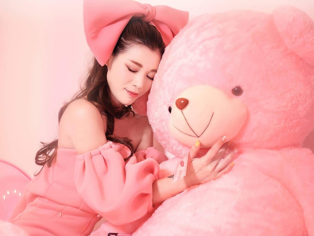 Красивая девушка азиатка с большим розовым медведем