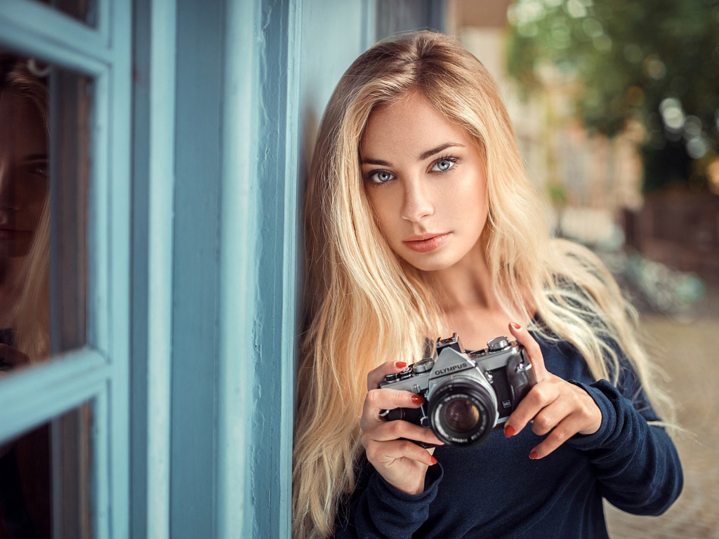 Красивая девушка блондинка с фотоаппаратом 