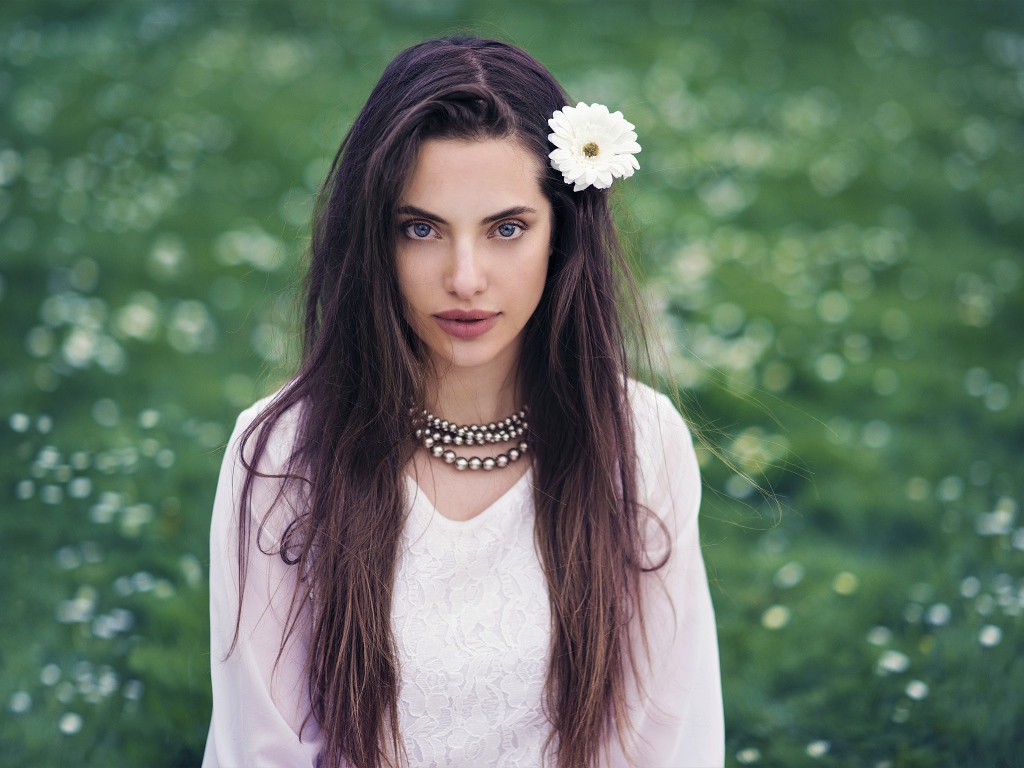 Красивая голубоглазая брюнетка с белым цветком в волосах