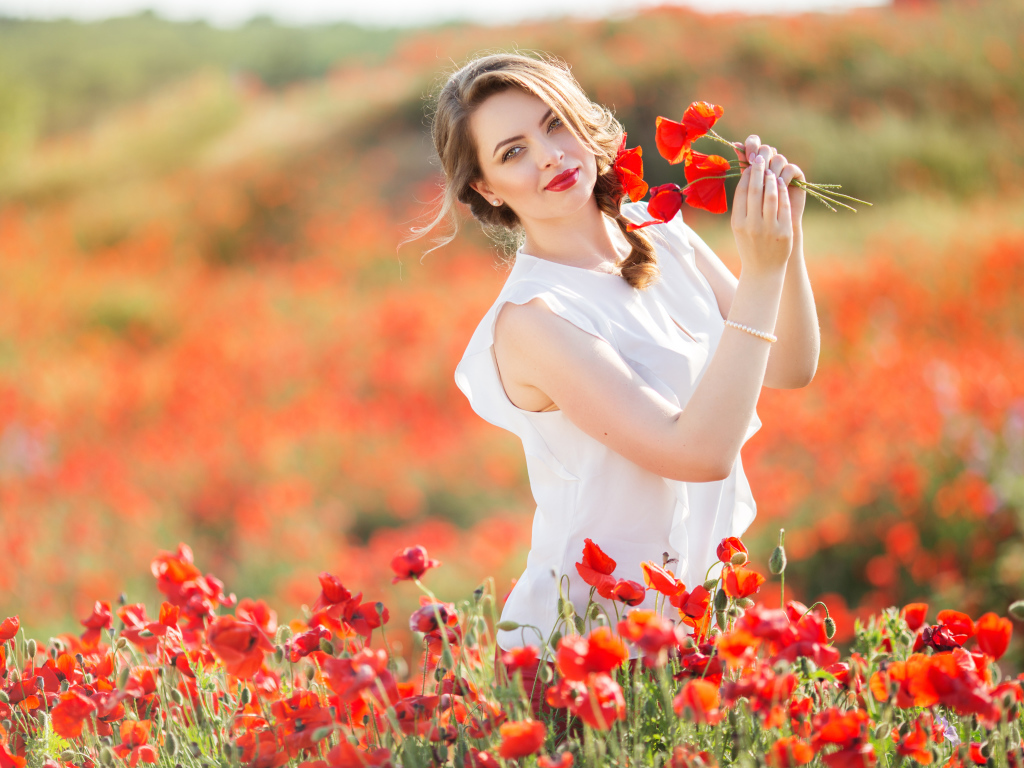 Красивая девушка в белом платье с букетом маков в руках