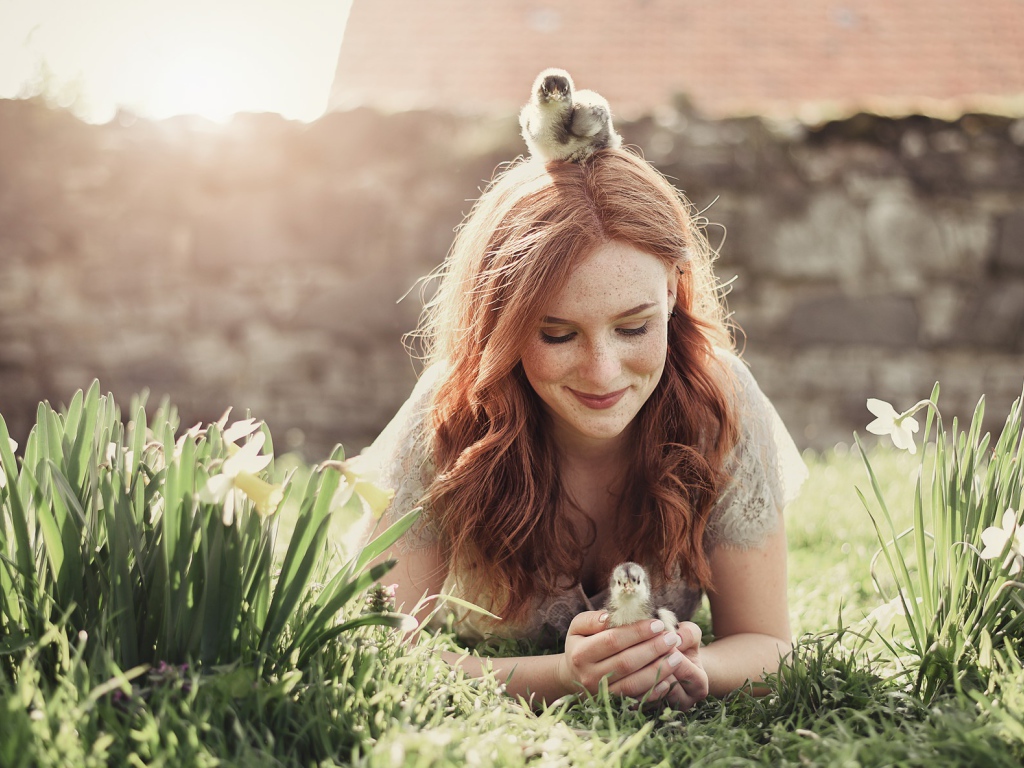 Красивая рыжеволосая девушка с маленькими цыплятами  