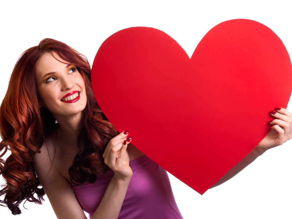Красивая улыбающаяся девушка с большим красным сердцем в руках