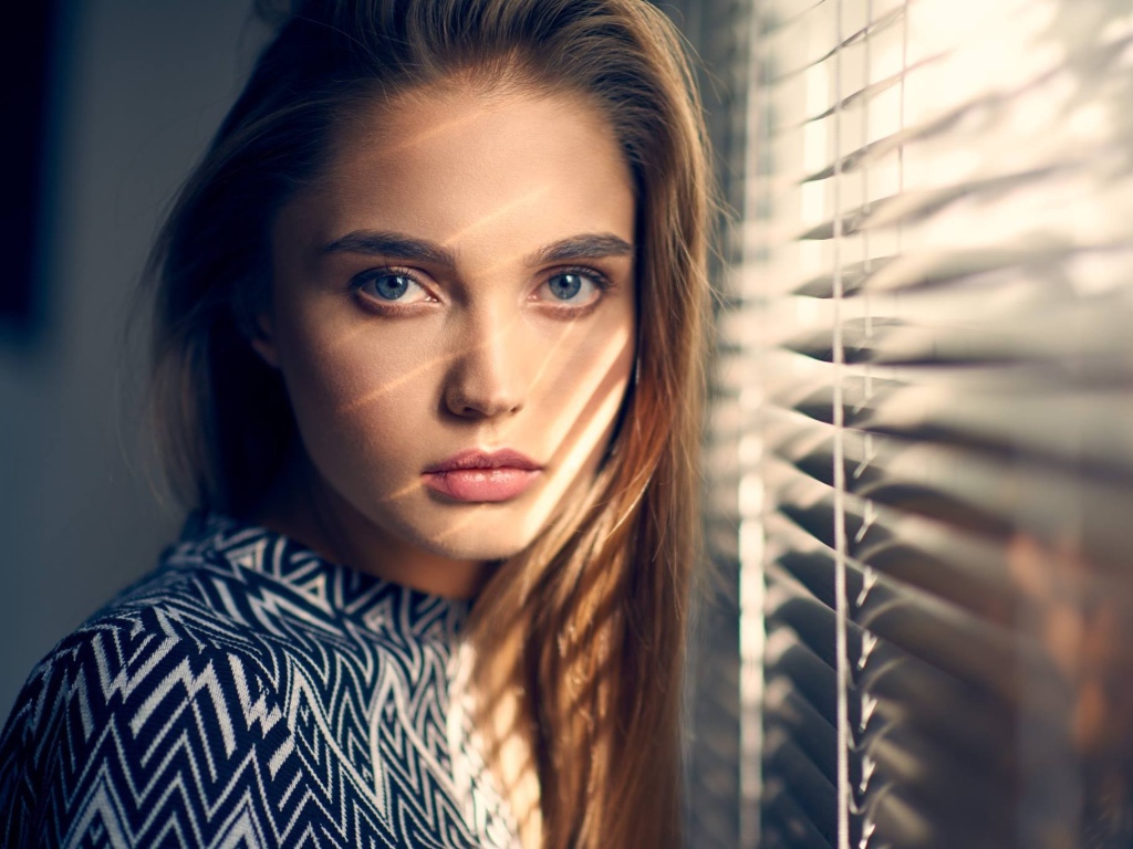 Девушка блондинка с голубыми глазами у окна 