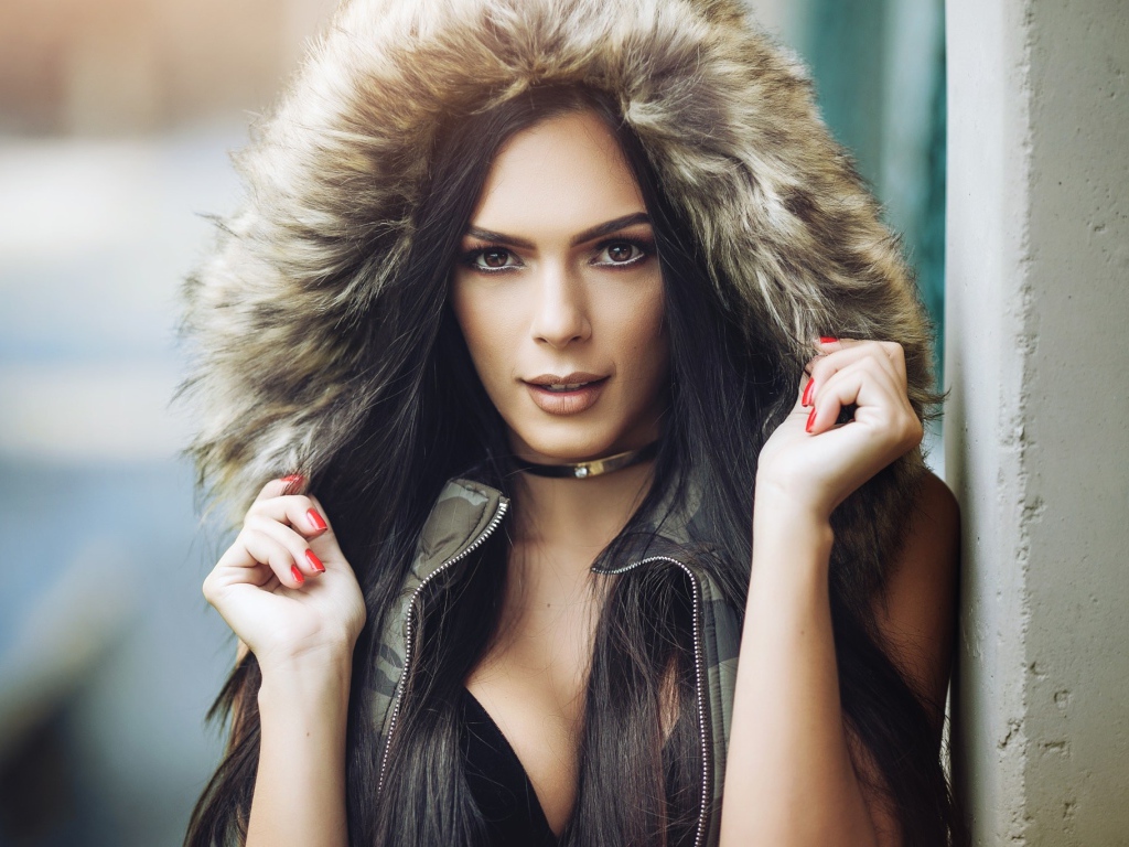 Брюнетка в капюшоне с красными ногтями на руках 