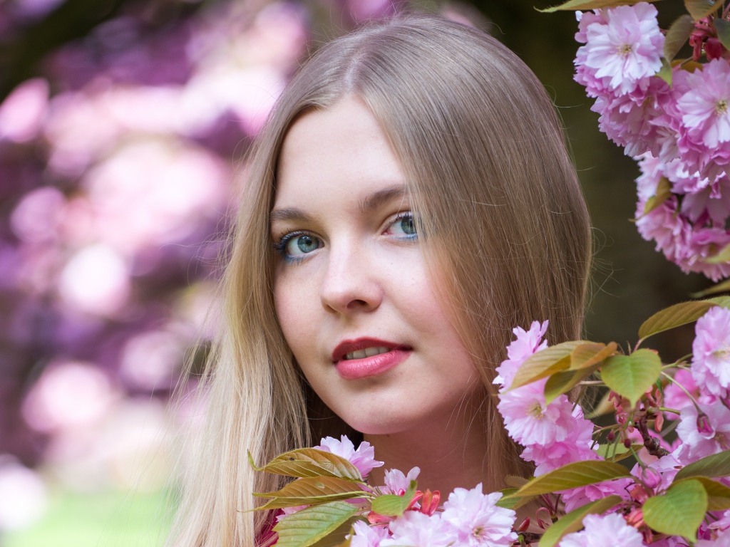 Милая голубоглазая девушка с розовыми цветами 