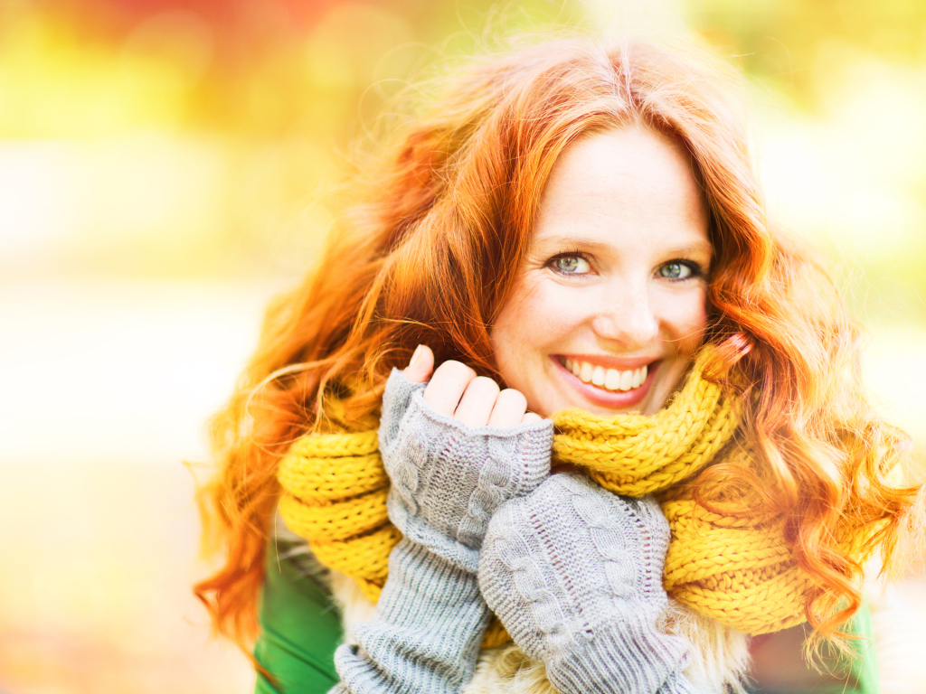 Улыбающаяся рыжеволосая девушка в теплом шарфе
