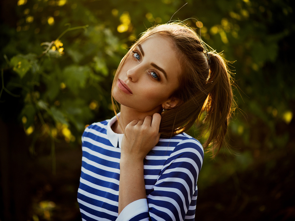 Молодая голубоглазая девушка в полосатом платье