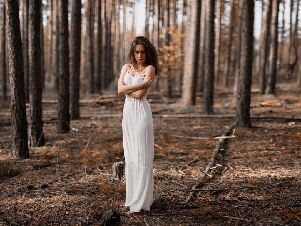 Молодая девушка в белом платье в лесу 