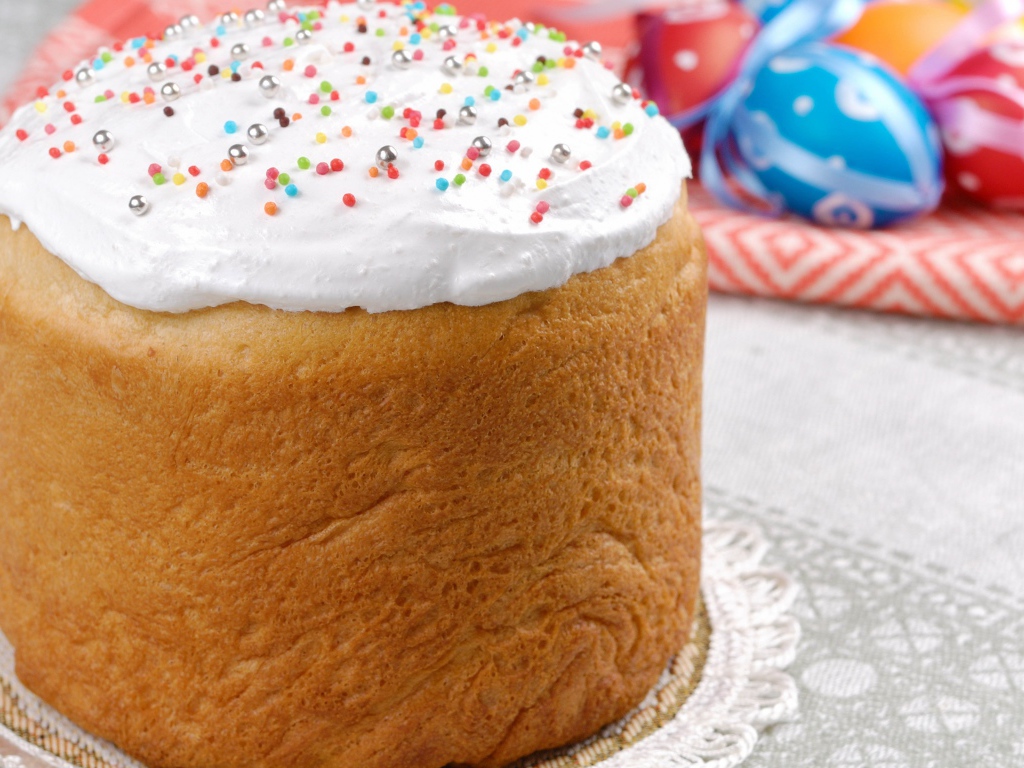 Пасхальный кулич с белой глазурью на столе 