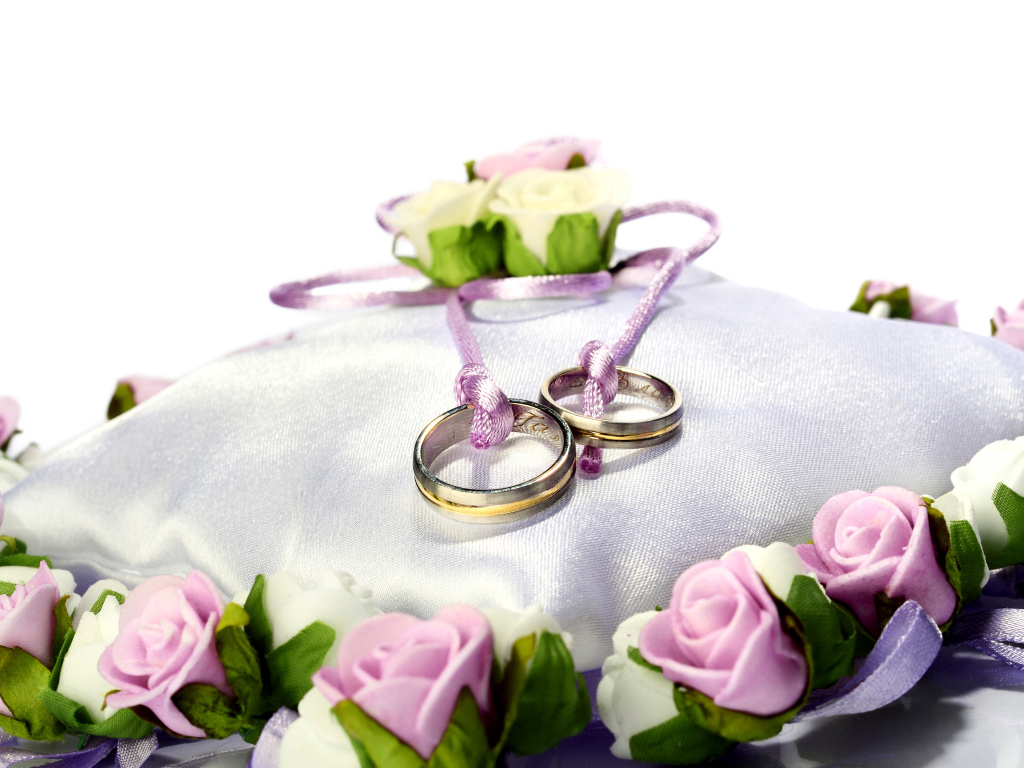 Два золотых обручальных кольца на подушечке на свадьбу