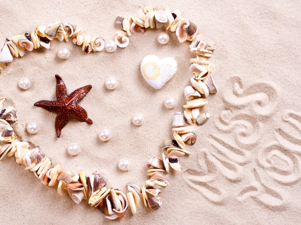 Сердце из ракушек на песке  