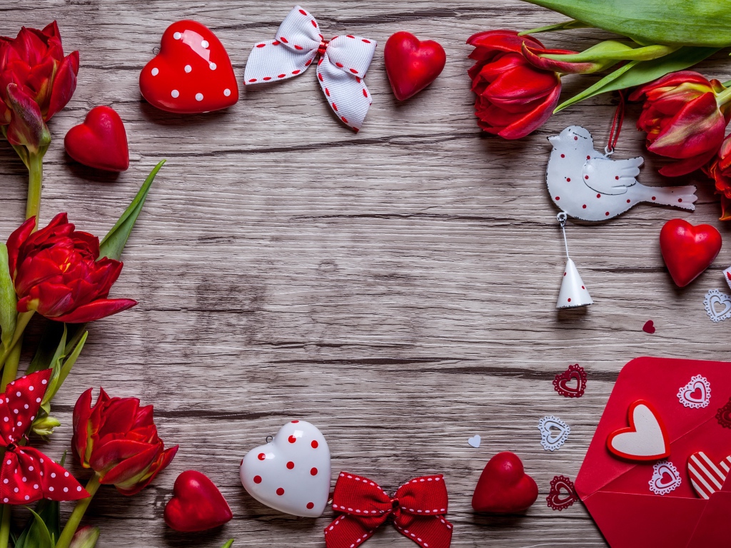 Красные тюльпаны с сердечками и бантиками на деревянной поверхности