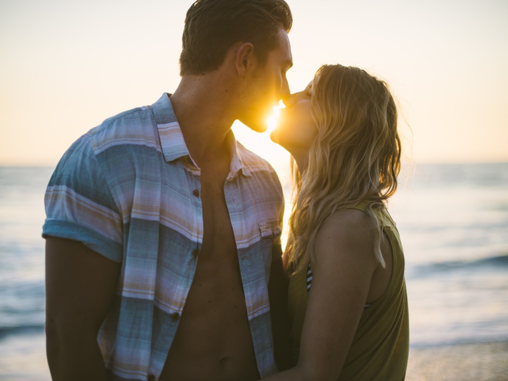 Романтический поцелуй влюбленной пары на закате солнца