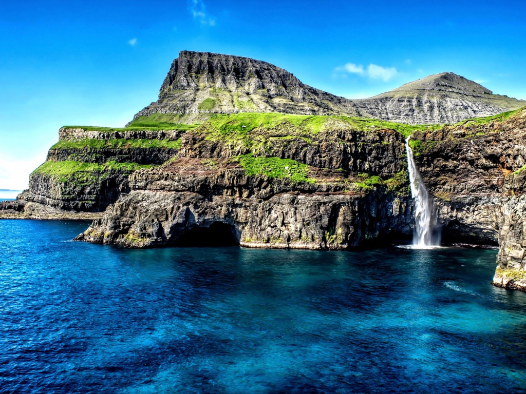 Маленький водопад стекает со скалы в океан, Гавайские острова