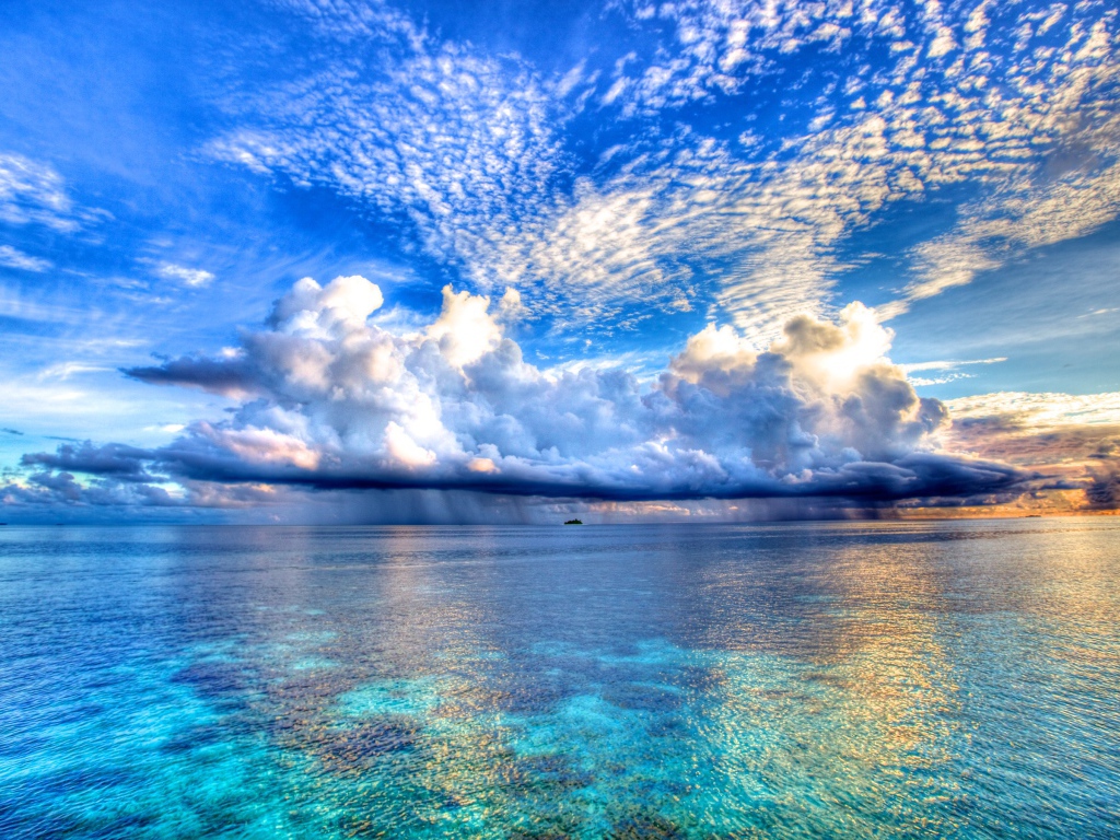 Красивые облака отражаются в голубой воде океана